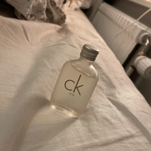 CK One parfym från Calvin Klein - Säljer en flaska CK One parfym från Calvin Klein. Flaskan är i frostat glas med en enkel och stilren design. Den har en metallfärgad skruvkork och rymmer en fräsch och unisex doft som passar alla tillfällen.