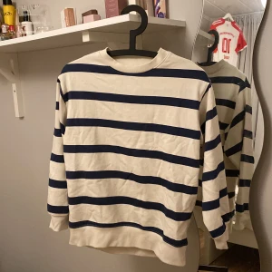 Randig tröja från Cubus - Säljer en stilren randig tröja från märket Cubus i storlek 134/140. Tröjan har ett klassiskt blått och vitt randigt mönster och är tillverkad i ett mjukt material. Perfekt för en avslappnad look.