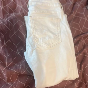 Vita jeans med fransar - Snygga vita jeans med fransiga kanter och klassisk femficksdesign. De har en dragkedja och knapp framtill. Perfekta för en stilren look. Ny pris 399kr