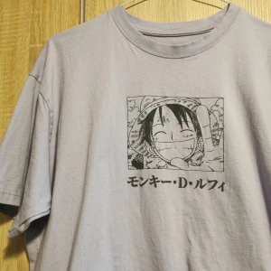 (M) Ljuslila One Piece t-shirt från Pull&Bear - Ljuslila t-shirt från Pull&Bear med Luffy från One Piece på både fram- och baksidan. Tröjan och trycket är i en något blekare färg, men var så när jag köpte den. (köpte i två storlekar och kunde därför jämföra). Endast använd en gång! 