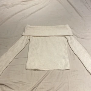 Vit ribbad offshoulder tröja från H&M - Säljer en stilren vit ribbad offshoulder tröja från H&M. Perfekt för en trendig look med långa ärmar och en bekväm passform. Passar utmärkt till både jeans och kjol. 🌟