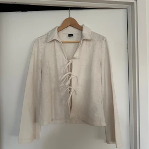 Vit blus med knytning - Säljer en stilren vit blus från Gina Tricot med knytning framtill. Blusen har långa ärmar, en klassisk krage, och sydd i linnematerial🤍