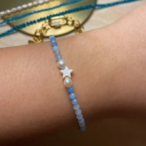Handgjort blått armband med pärlor och stjärndetalj - 🌸 Rostfritt stål 🌸 Sötvattenspärlor och Stjärna av snäckskal 🌸 Kristallpärlor på 3 mm 🌼 Justerbar passform – bekväm och flexibel storlek från cirka 16 till 24 cm för att passa alla handleder.   🌼Vårdande användning – undvik långvarig kontakt med vatten för att bevara den naturliga pärlan. Långvarig vattenexponering kan leda till att pärlan blir skör och går sönder!  ⭐️Har du extra små eller stora handleder kan du kontakta mig så justerar jag bandet!❤️)