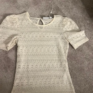 Beige spetsblus - Säljer denna så fina spets topp från vila. Säljer pågrund av att den inte kommer till användning längre.