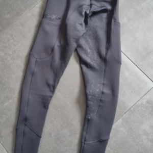 Ridbyxor/ridleggings ZacZess - Snygga grå ridleggings från ZacZess med praktiska fickor och förstärkta partier för extra hållbarhet. Perfekta för ridning med en tight passform som ger bra rörelsefrihet. Stilren design med diskret logga på sidan. Storlek XXS men skulle säga att de är XS 