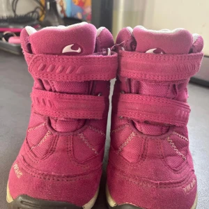 Rosa barnskor från Viking - Säljer ett par rosa barnskor från Viking med kardborreband och robust sula. Skorna är tillverkade i mocka och har en bekväm passform. Perfekta för aktiva barn som behöver slitstarka skor.