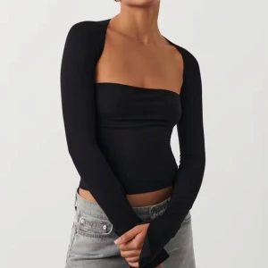 Svart offshoulder topp - Jättesnygg svart långärmad topp i mjuk viskos med fyrkantig halsringning. Toppen är supermjuk har figurnära passform. Den har även slits vid ärmsluten och croppad längd. Jättefint skick använd max 3 gånger! Säljer då jag har 2 likadana🩵🩵(nypris 260kr)