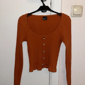 Orange ribbad topp - Snygg orange ribbad topp från Gina Tricot med knappar framtill, croppad passform. Endast testad, strl XS.