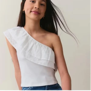 One shoulder blus - Fin vit one shoulder blus med spets och volang!! Skriv för fler bilder eller frågor💞