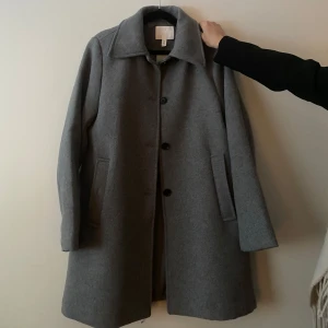 Grå kappa - Säljer en varm, grå kappa från HM, helt ny med prislappen kvar, endast provad. Storlek S