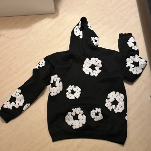 Denim tears hoodie  - Den har en klassisk passform med huva och långa ärmar. Perfekt för en avslappnad stil. 