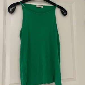 Grön linnetopp från Lindex - Snygg grön linnetopp från Lindex i en enkel och stilren design. Perfekt för varma dagar eller som ett lager under en jacka. Tillverkad i ett mjukt och bekvämt material.