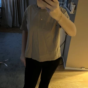 Beige t-shirt - Säljer en enkel och stilren beige t-shirt med normal passform. Perfekt för en avslappnad look. Gina