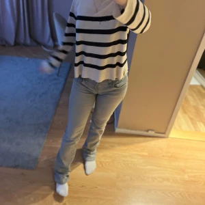 Randig tröja i svart och beige - Säljer en snygg randig tröja i svart och beige. Tröjan har långa ärmar och en avslappnad passform, perfekt för en casual look. Den är gjord i ett mjukt material som känns skönt mot huden.