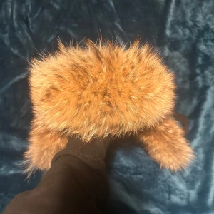 Svart pälsfodrad hatt från Canada Goose aviator  - Säljer en svart hatt från Canada Goose med pälsfoder. Hatten har ett broderat märke på sidan och är perfekt för kalla vinterdagar. Den är designad för att hålla dig varm och bekväm. Canada goose aviator