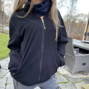 Svart fleecejacka med dragkedja - Säljer en svart fleecejacka med dragkedja framtill. Jackan har långa ärmar och praktiska fickor med dragkedjor. Perfekt för kyliga dagar.