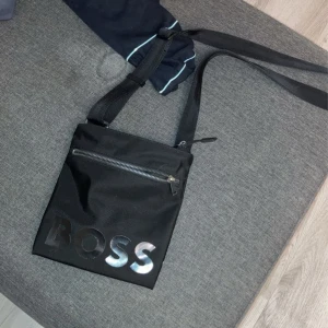 Hugo boss väska.  - Hej, säljer min Hugo boss väska pågrund av att den inte används, inte riktigt min smak. Den är helt ny och inga fel på den. 