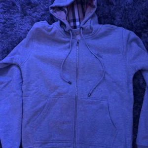 Burberry Hoodie  - As snygg burberry zip hoodie säljes pga för liten. Orginal förpacknings påse medföljer. Kan skicka direkt. Obs klicka inte på köp nu. Eventuellt byte mot storlek L. De riktigt bra pris o skick som ny. 