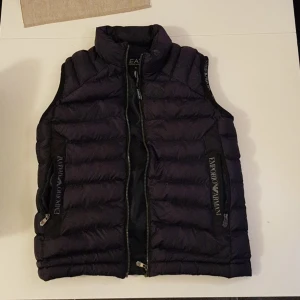 Emporio Armani väst - Emporio Armani väst perfekt till sommar kvällar, hösten och våren. Det står storlek M men sitter bättre för S. Fickorna är små men riktigt fet väst ändå. Inga defekter då västen är knappt använd eftersom den är för liten till mig.
