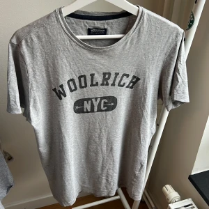 Woolrich t shirt - Grå woolrich T shirt, bra skick men tecken på användning (7/10) storlek S men passar 175-180 skulle jag säga. Skriv om ni har någon fråga eller fundering.