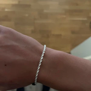 Silverarmband med tvinnad design - Säljer ett snyggt silverarmband med en elegant tvinnad design. Armbandet är silverpläterat och har en 925 stämpel. Armbandet kommer i en stilren svart förpackning. Perfekt för både vardag och fest!💎🤩