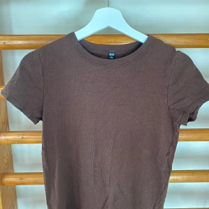 Brun T-shirt  - Ribbad brun T-shirt från uniqlo. Storlek M. Inga fläckar. 