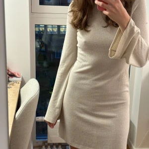 Stickad klänning med öppen rygg - Superfin kort stickad klänning med öppen rygg som knyts i nacken från Nelly i storlek XS. Har normalt storlek S så den är stor i storleken! Nyskick, använd 2 gånger. Har en liten rosa sminkfläck på höger ärm. Inköpspris 399kr