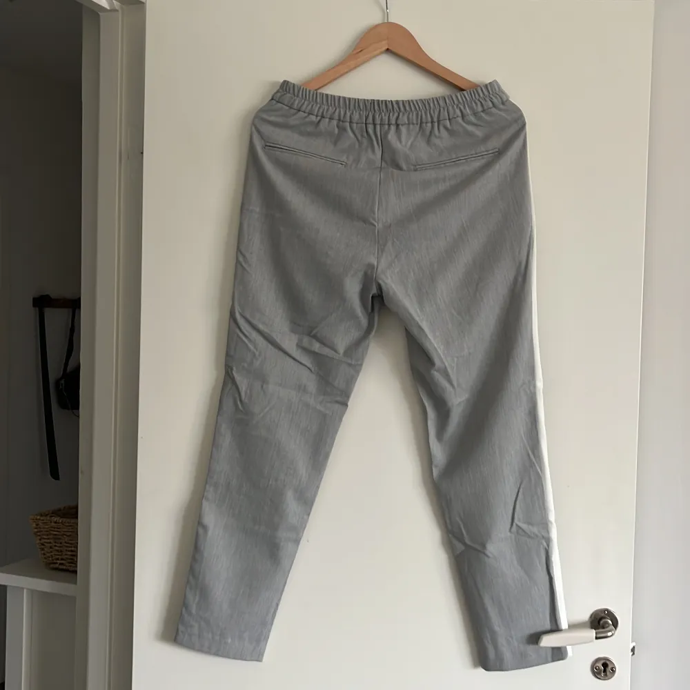 Gråa kostymbyxor med vit rand på sidan av benen, resårband bak. Strl S från Zara Man.. Jeans & Byxor.