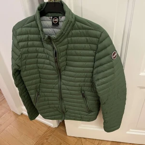 Grön pufferjacka från Colmar🔥⚡️ - Säljer en snygg grön pufferjacka från Colmar. Den är perfekt för höst och vår med sin quiltade design och dragkedja framtill. Jackan har långa ärmar och två praktiska fickor med dragkedjor. Passar fett snyggt med jeans och ass fräsch🔥🔥⚡️