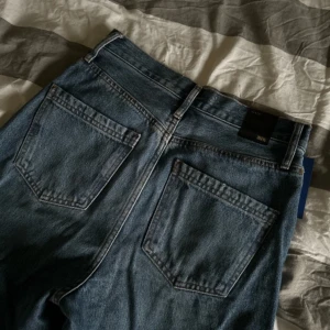 Blå jeansbyxor - Säljer ett par klassiska blå jeansbyxor som är vida i benen. De är högmidjade och har en rak, avslappnad stil. Perfekta för både vardag och fest! 🕺Knappt använda.