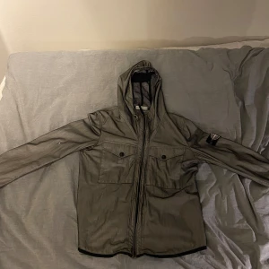 Stone island windbreaker - En stone island windbreaker i strl L. Jackan är använd och har små defekter på ärmarna men annars i bra skick!  Hör gärna av dig ifall du är intresserad!😊