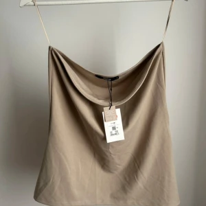 Tubtopp  - Tubtopp med en liten mini sluta på sidan. Stretchigt material.