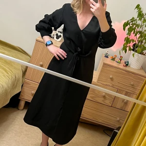 Twist & Tango svart klänning, storlek 36 - Svart klänning med långa ärmar och V-ringning. Klänningen har en knut i midjan och är tillverkad i ett mjukt och bekvämt material. Storlek 36 Köpt i NK för 2700 kr  använd par gånger 