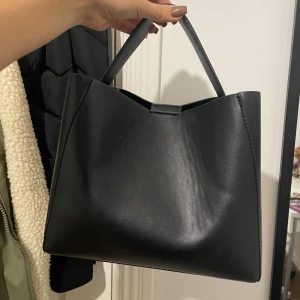 Virala Gina Tricot väskan - Säljer min gina tricot väska som är svart och i storlek M (utan något axelband). Innerfickan har en liten öppning (se andra bilden) annars är väskan i fint skick.