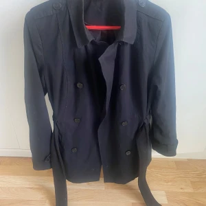 Svart snygg coat kappa - Använts under sommaren, stillig kappa med knappar.