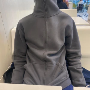 Grå fleecejacka med dragkedja - Mysig grå fleecejacka med dragkedja framtill. Perfekt för kyliga dagar och har en enkel, stilren design. Jackan har långa ärmar och är i normal passform. Perfekt för både vardag och avslappnade aktiviteter.