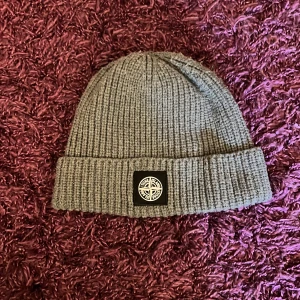 Stone island mössa  - Grå Stone island mössa som tyvärr har tappat ett ”S”men det syns fortfarande. Helt äkta. Pris går såklart att diskutera.🤝🏼