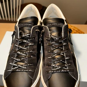 Philippe Model - Philippe Model, storlek 45 i svart. Köpta i början av sommaren 2024, säljs pga för liten storlek, därför använda endast ett fåtal gånger. Skick 8/10. Ny pris 3600kr. Box ingår.