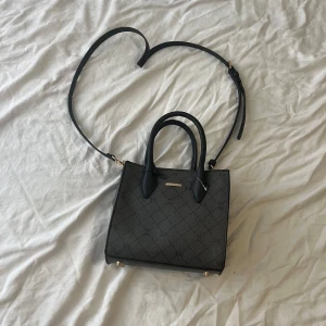 Liten handväska  - En liten handväska med 3 olika fack som är köpt i polen.