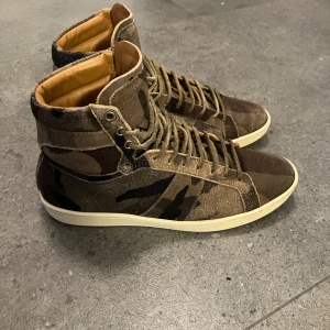 Saint Laurent  - Höga camoflauge saint Laurent skor, använda men bra skick strl 41. OBS inget og medföljer, bara skorna 