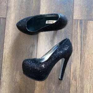 Helt nya Svartglittriga Pumps - • Aldrig använda endast provade • Upplevs som storlek 36 • Rekommenderar klackvana fötter • Bild 1 och 4 visar bäst hur de ser ut i verkligheten och färgen • Passar Smala-Normala fötter • Platå ca 4 cm • Klack ca 13 cm • Kommer i inköpslådan