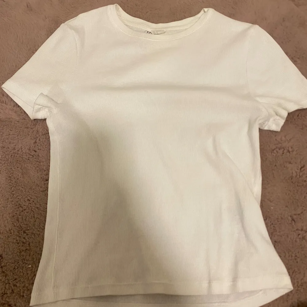 Ribbad, vit T-shirt från hm. Den har en fläck i bak som fanns när den köptes men jag märkte det senare. . T-paidat.