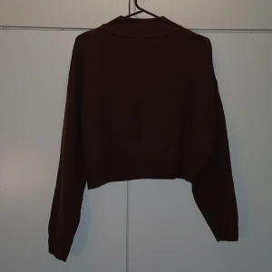 Brun stickad långärmad tröja - En brun stickad långärmad tröja. Den sticks inte. Den är lite kortare men jag skulle inte räkna den som en magtröja. Kragen är lite högre men inte direkt polo stuk. Passar perfekt till hösten och vintern. Den har använts bara ett fåtal gånger.