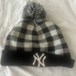NY vintermössa - Svart vit vinter/ höst mössa från NY med mönster och pälsboll. Kommer inte till användning och säljs därför 🔥