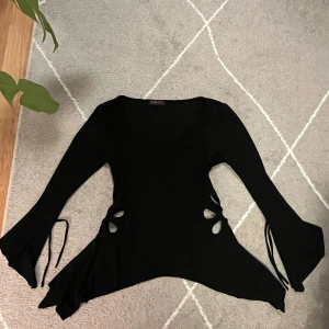 Topp - Trekvartslånga, utsvängda ärmar med utskurna blommor vid midjan! Superfina detaljer och elastiskt, mjukt tyg. Snören vid ärmarna:) Toppen är vringad, svårt att se på bild. Passar S-M