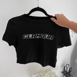 Svart crop top med strass - En svart croppad t-shirt med strass. Säljer pga att den aldrig kom till användning 🤍 Liten i storleken då den passar mig som har S. Passar även till M 💞  (ALDRIG ANVÄND)  Längd: 40 cm Axel: 39 cm Byst: 88 cm  