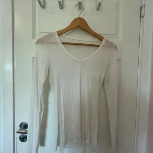 Vit kashmirtröja från Intimissimi - Säljer en supermjuk och lätt vit tröja från Intimissimi, gjord med kashmir. Den har en v-ringad design och långa ärmar, perfekt för både vardag och lite finare tillfällen. Tröjan är i nyskick och känns lyxig mot huden. Perfekt för höst och vår!