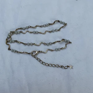 Halsband ped pärlor - Ett halsband med vita pärlor och silver vågor mellan dom