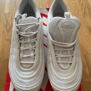 Nike sneakers / Nike Air Max 97 - Säljer ett par vita Nike Air Max 97 i nyskick. De har en stilren design med snörning och en bekväm passform. Perfekta för både vardag och träning. Använda en gång och är i storlek 39.