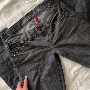 lågmidjade guess jeans - säljer dessa skitsnygga lågmidjade bootcut jeans från guess. jeansen e grå o har sååå snygga rhinestone detaljer på fickorna, tyvärr lite små för mig därför ja säljer🥲  mått: innerben 81 midja 40  storlek 28 men skulle säga xs/s